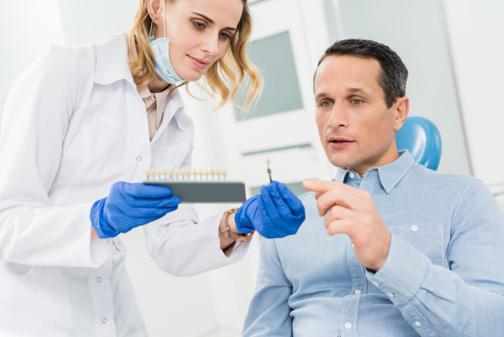 Female doctor and patient choosing tooth implants in modern dental clinic
