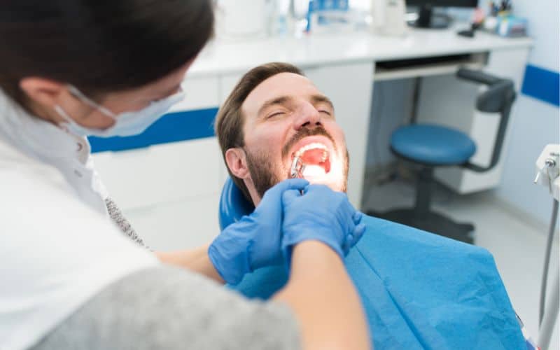 The dentist extracted the infected tooth of a man