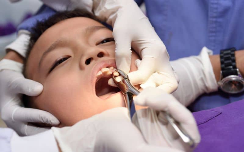 young boy during dental extraction