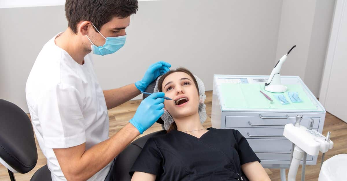 Dentist examining patient teeth with dental mirror