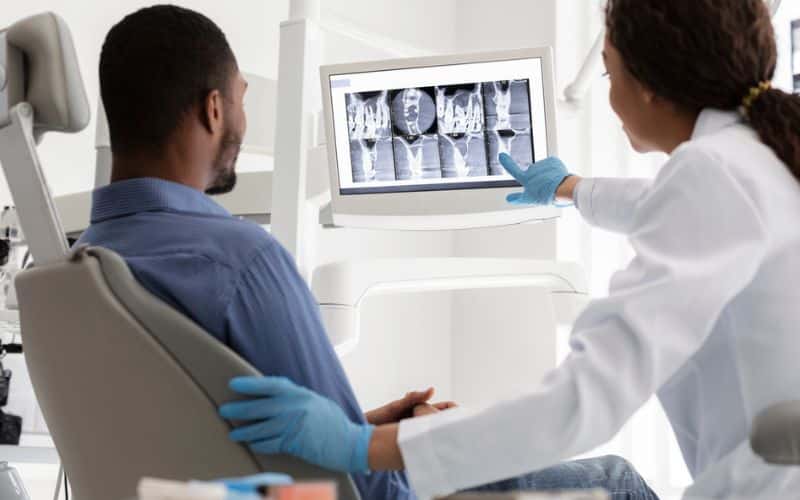 The dentist is performing a digital dental X-ray