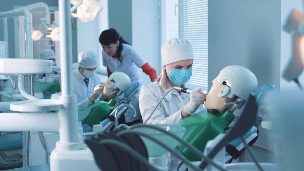 Dental students practicing dentistry in medical dummies