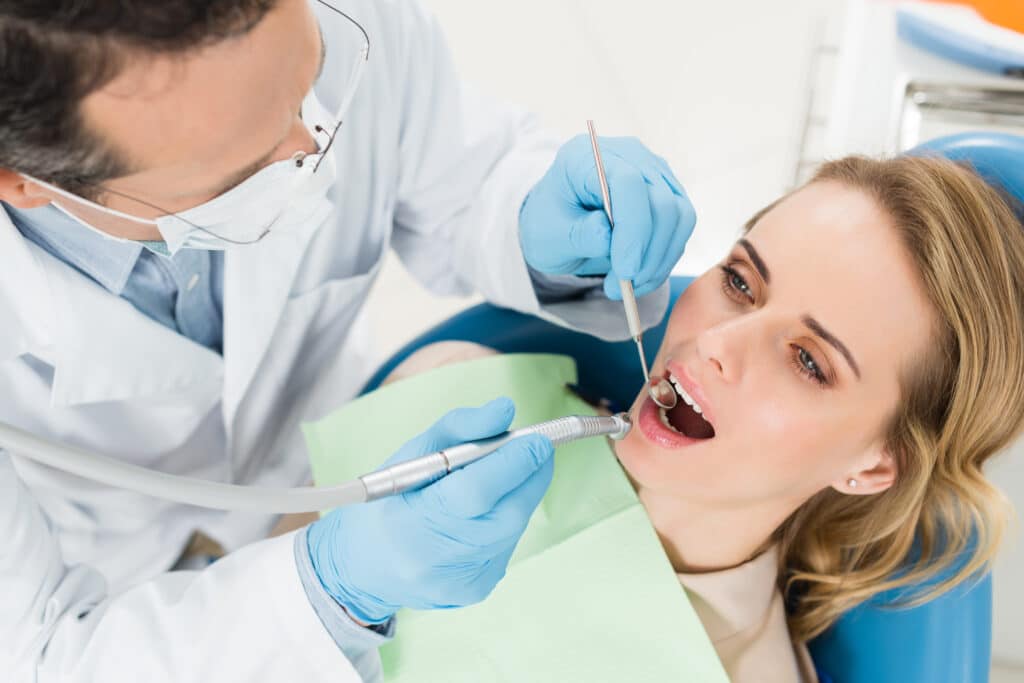 patient at dental procedure using dental drill in modern dental clinic