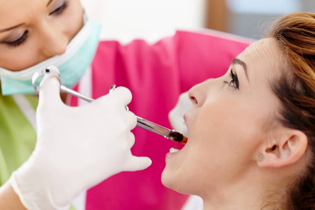 Closeup of a woman dentist giving her patient an anesthesia injection