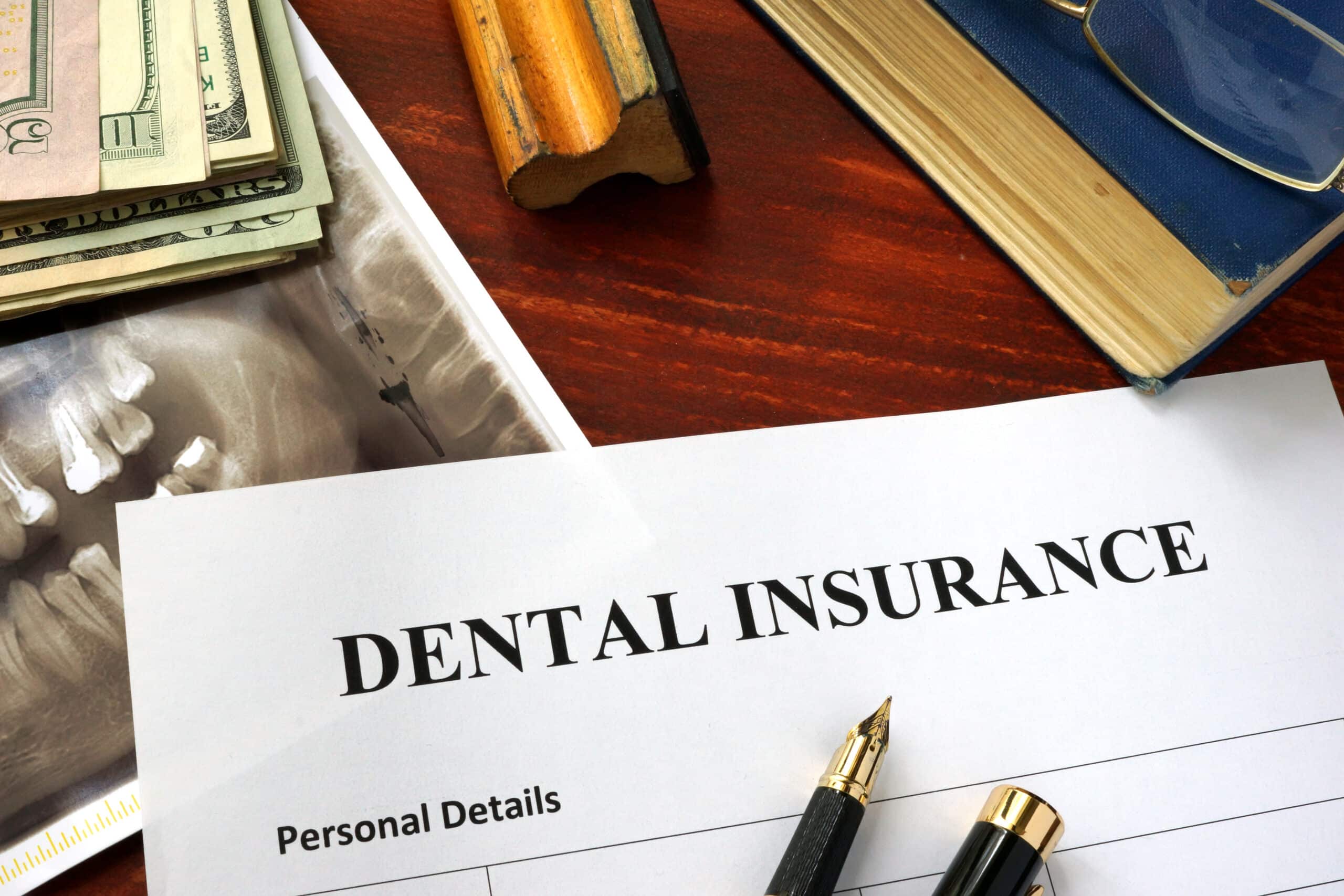 dental insurance policy on a table and a book 