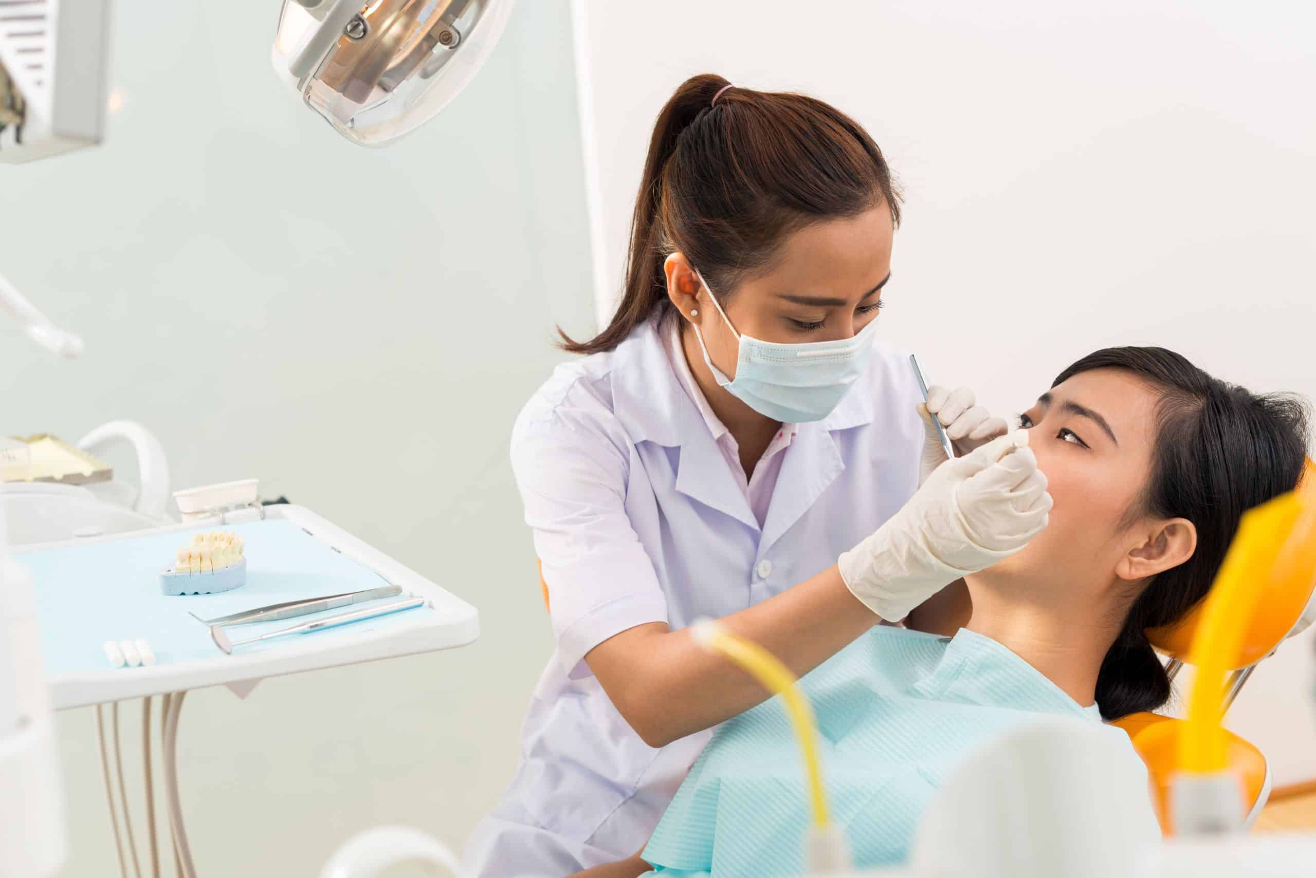 Female dentist examining the patient