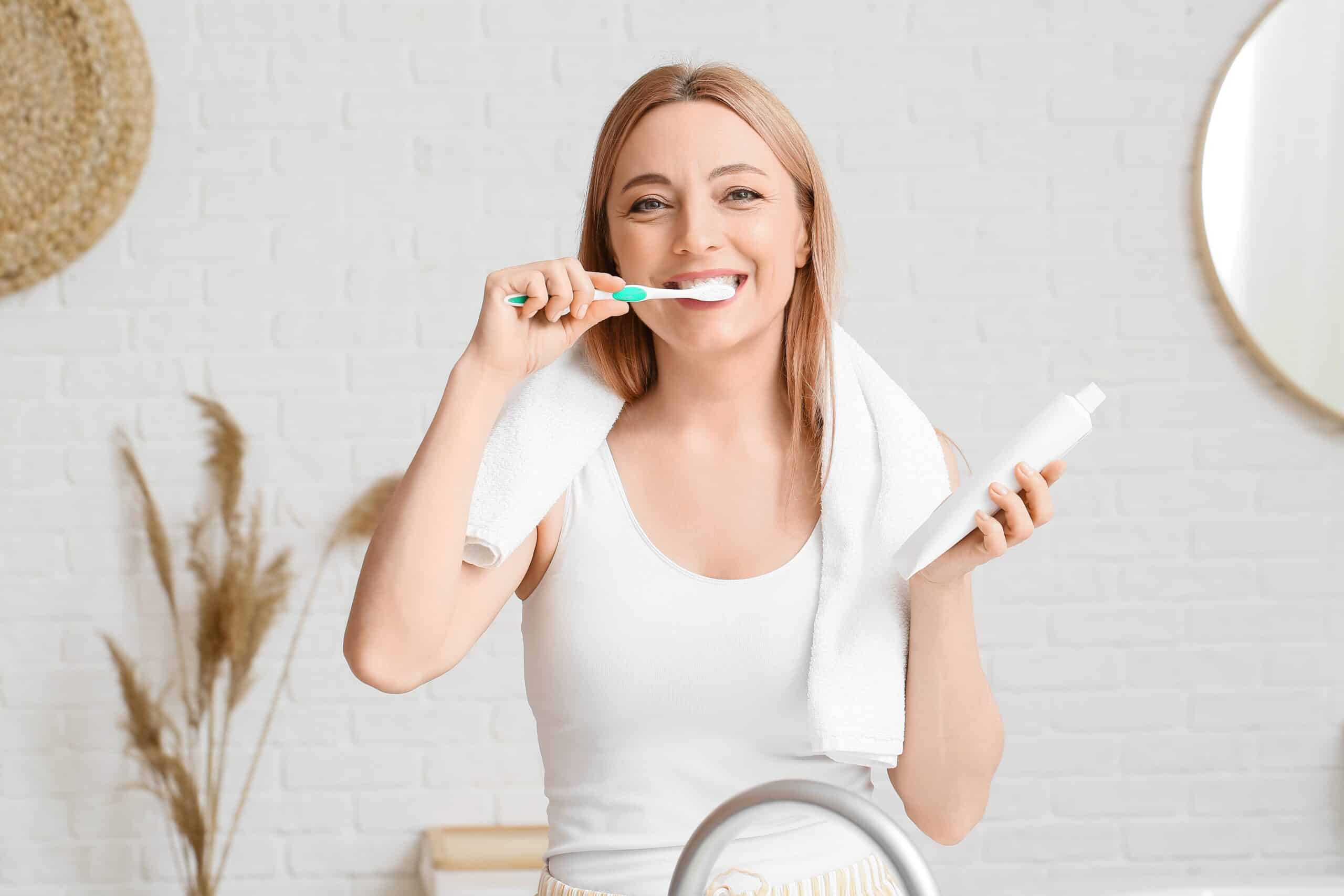 woman brushing teeth in bathroom