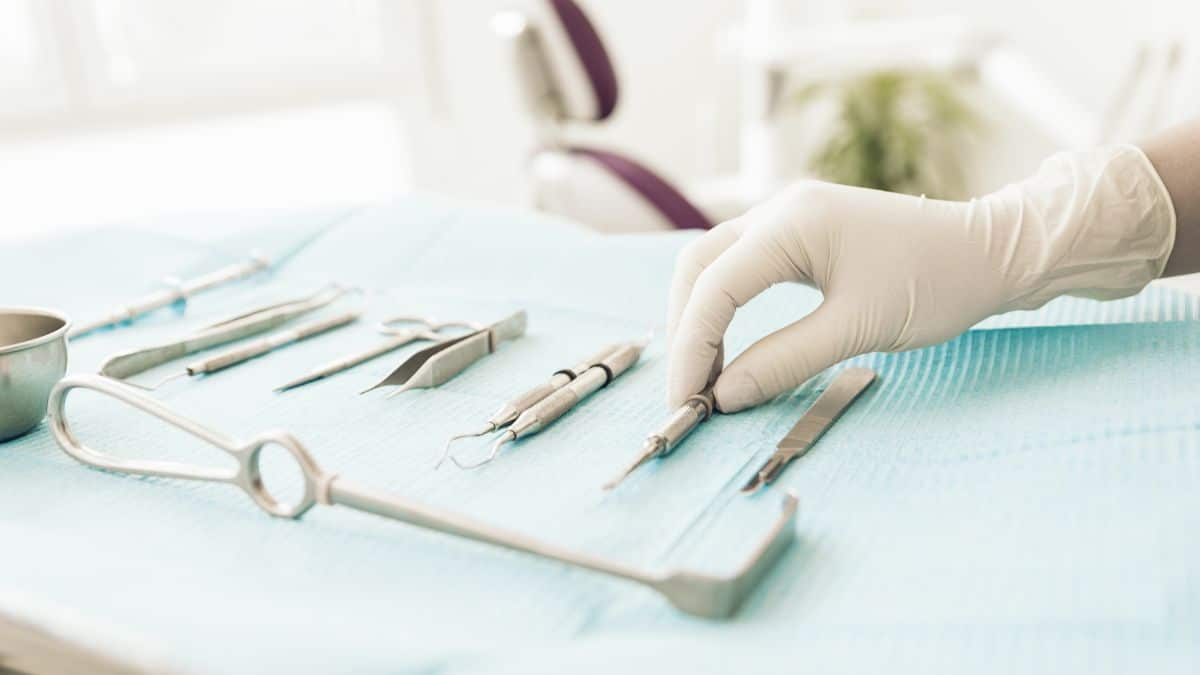 Detail of hand holding dental tools in dental clinic
