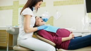 Pregnant woman laying on dental chair