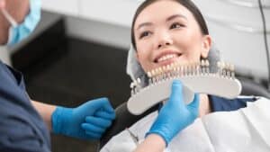 Odontologist selecting dental crown to beaming client