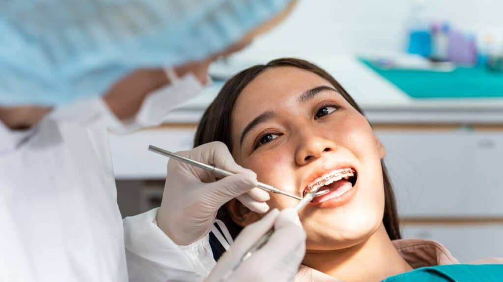 Attractive young girl with braces lying on dental chair
