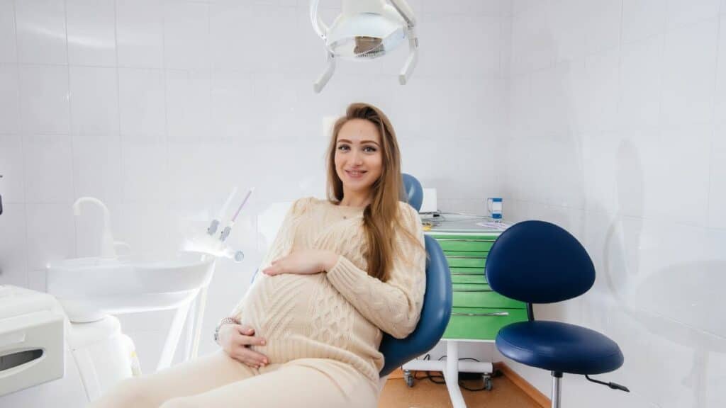 A professional dentist treats and examines the oral cavity of a pregnant girl