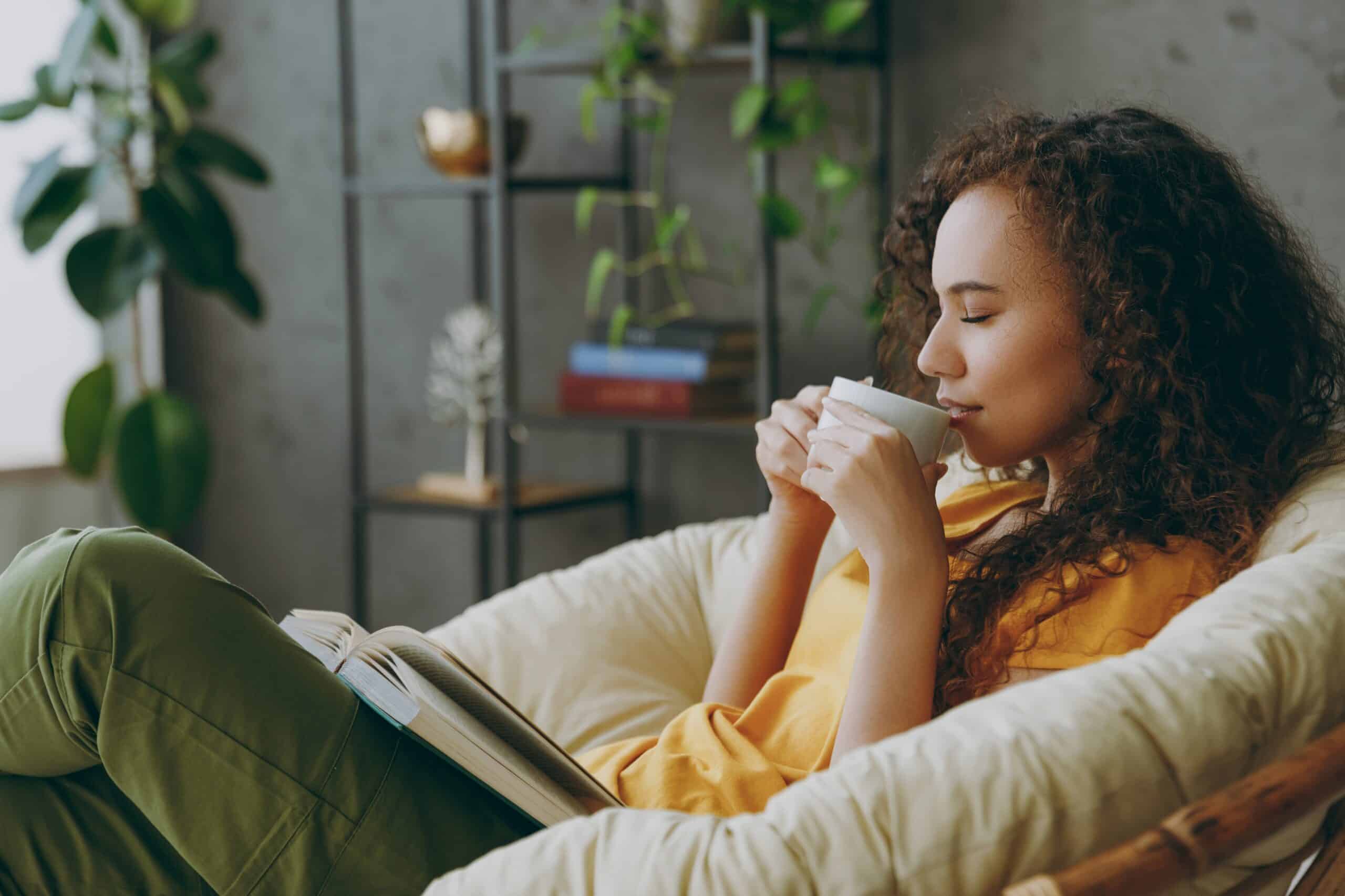 young woman drink coffee as a habit with book