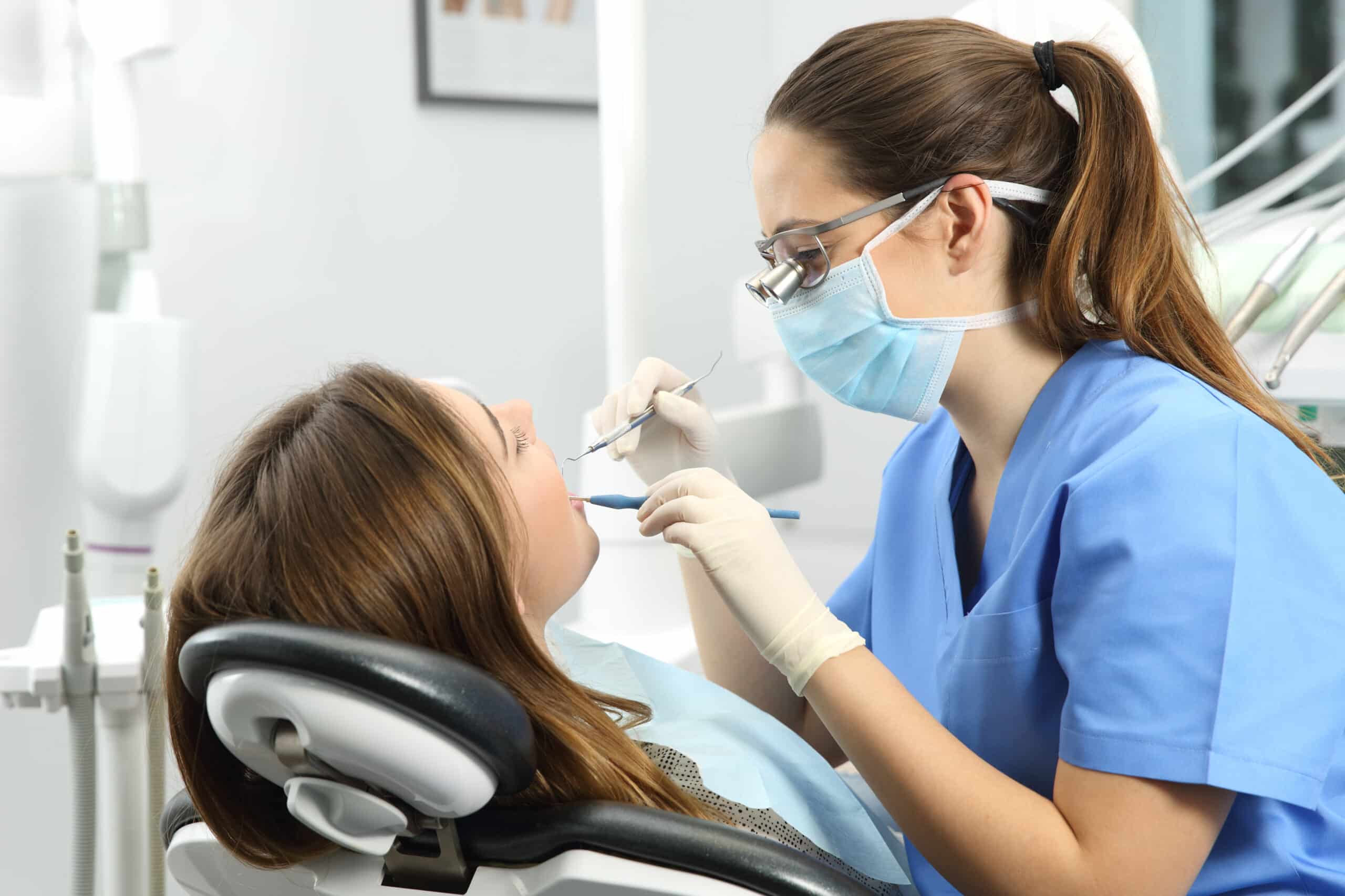 Dentist wearing eyeglasses gloves and mask Dental Procedures to a with 
Canker Sore